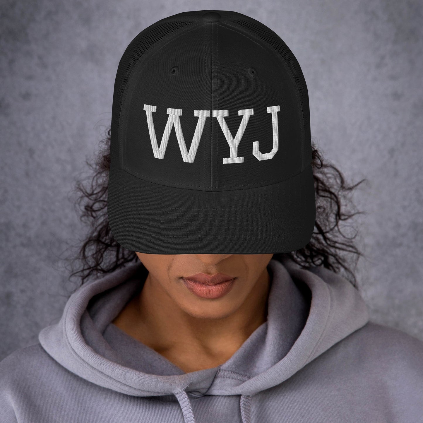Woman wearing a WYJ baseball cap showing  the front of the hat