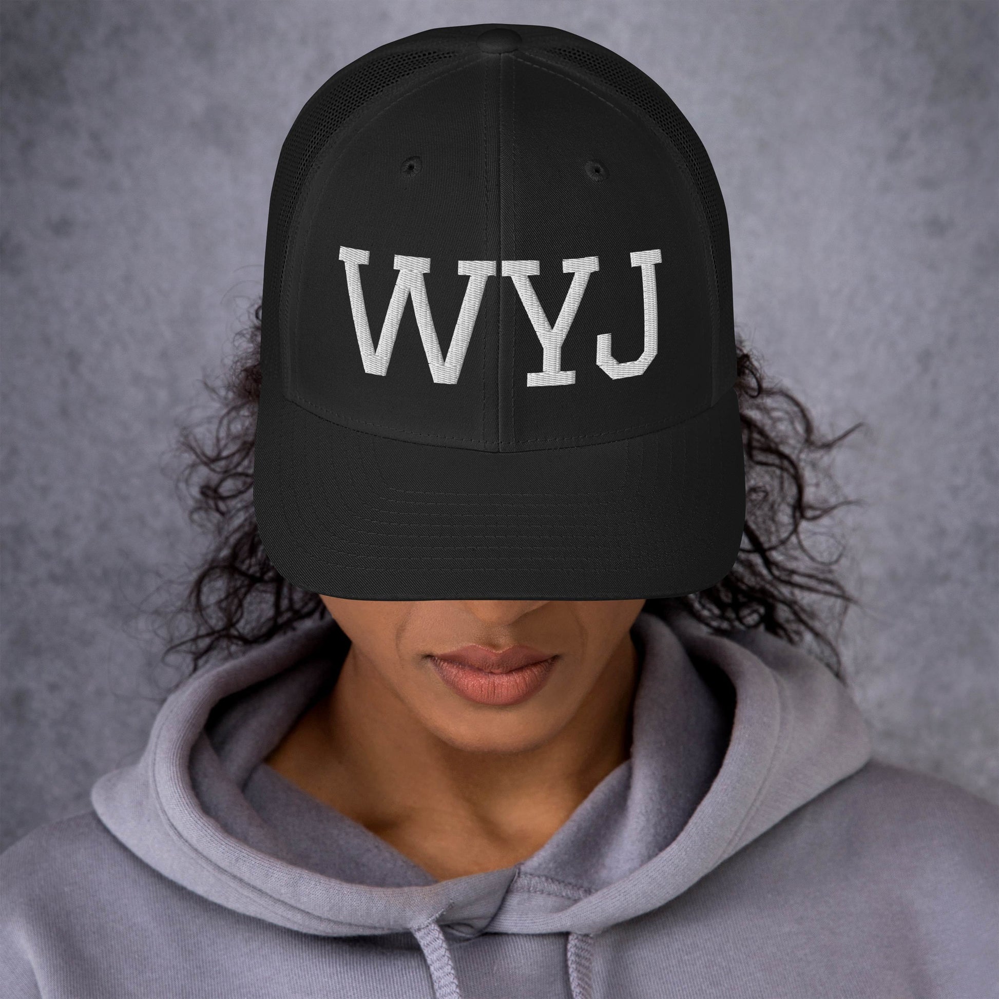 Woman wearing a WYJ baseball cap showing  the front of the hat