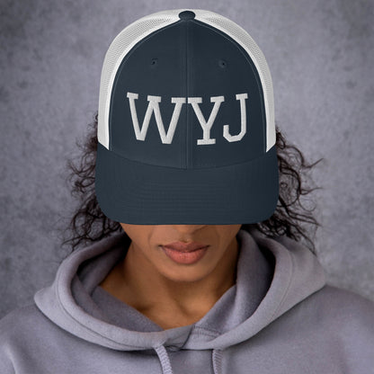Woman wearing a WYJ trucker cap showing  the front of the hat